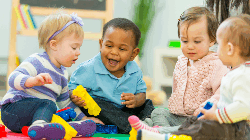 4 toddlers playing with blocks