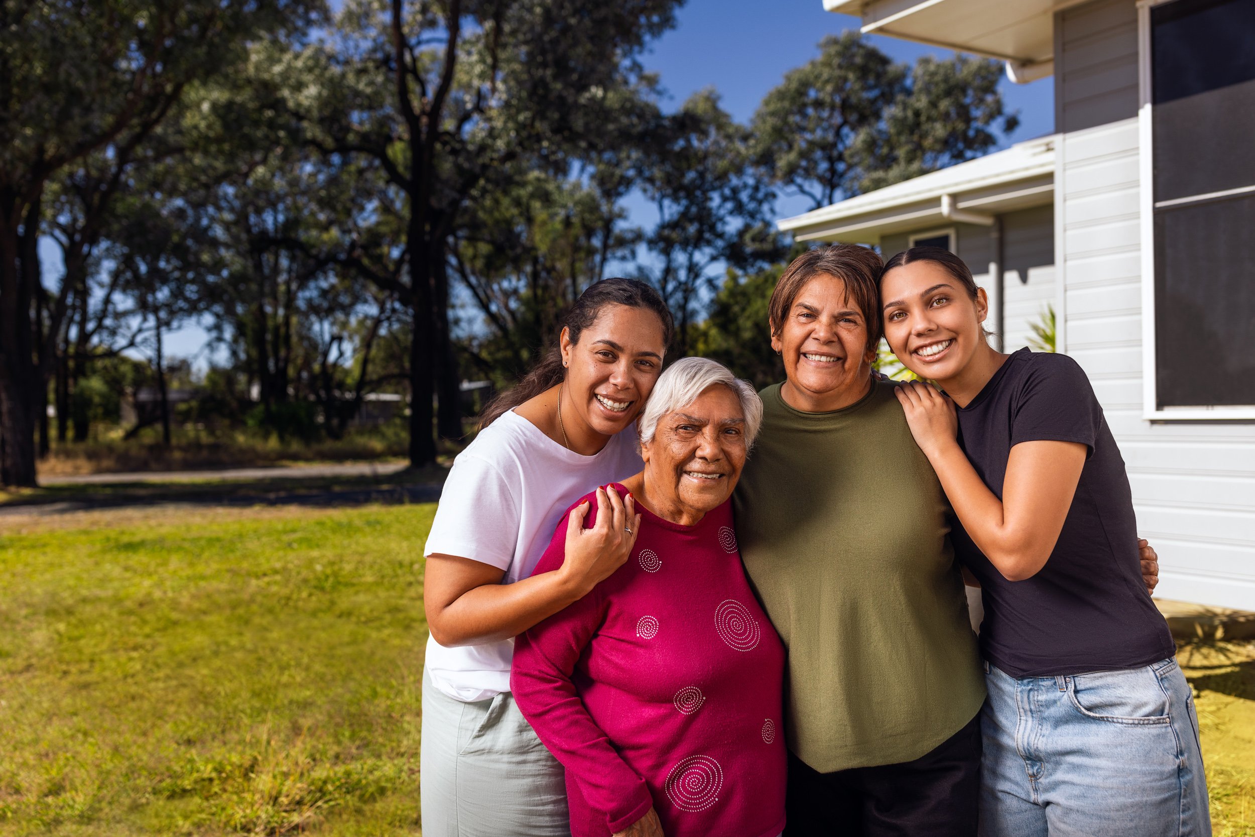 Four women, different generations standing side by side bugging.