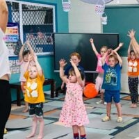 Young children participate in a group yoga class at school
