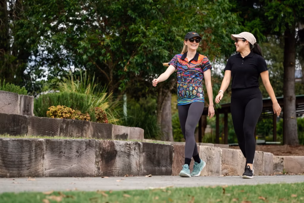 Two women together walking on footpath