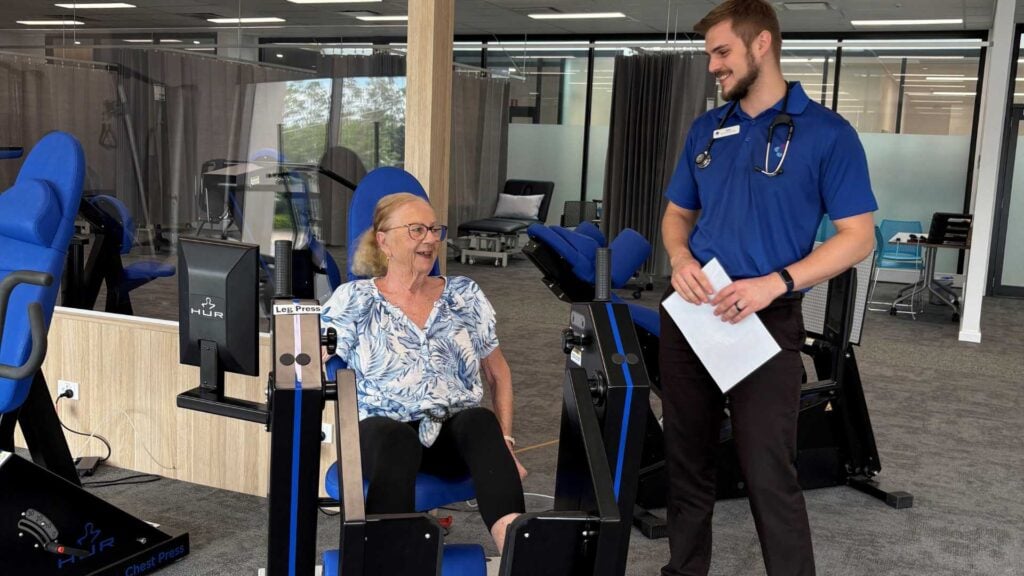 Maureen Trainor using gym equipment with instructor