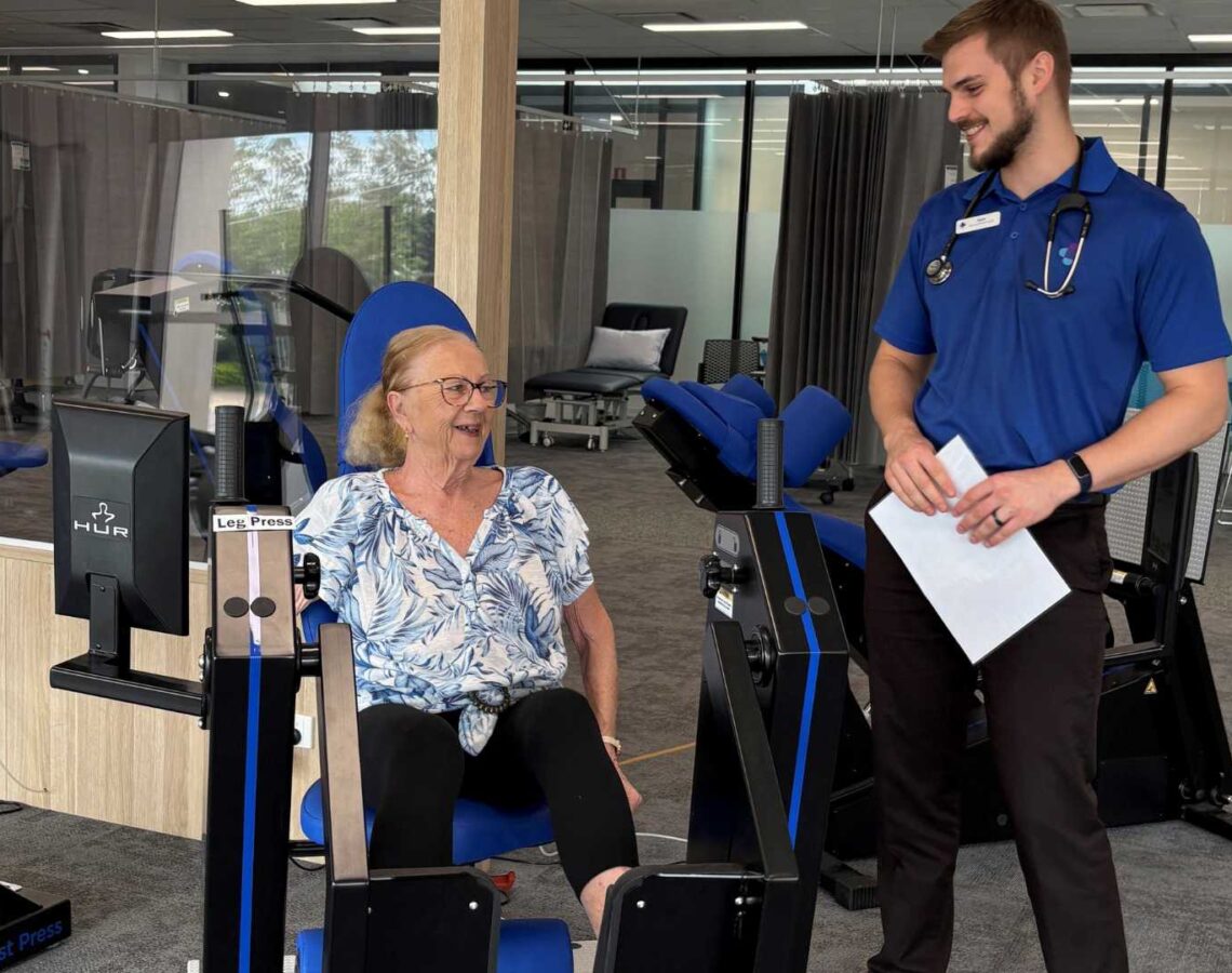 Maureen Trainor using gym equipment with instructor