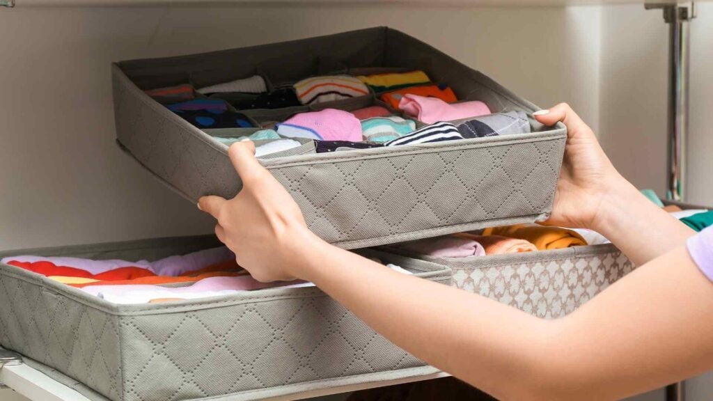 Girl places sock organiser on shelf