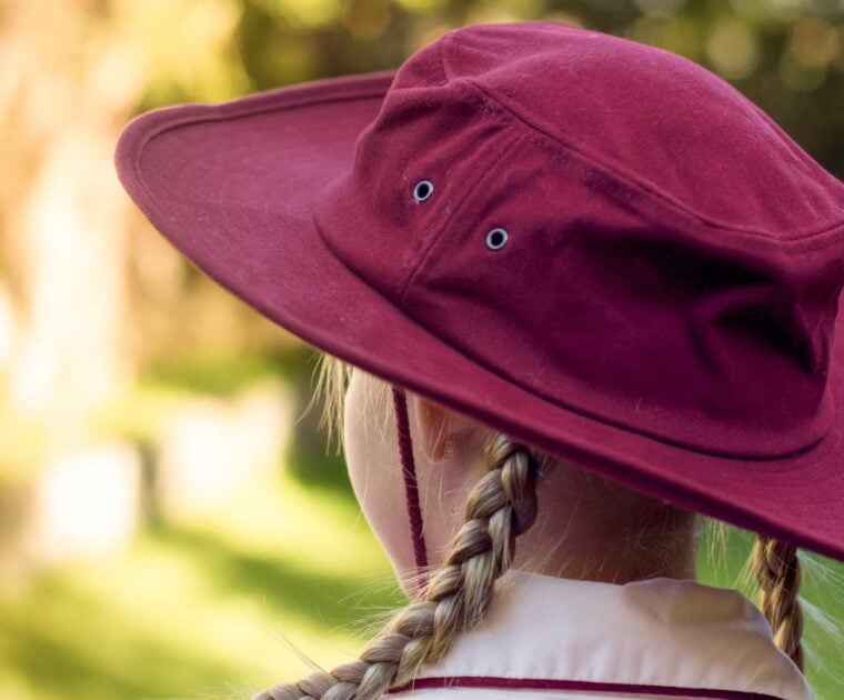 Girl wearing marroon coloured school hat