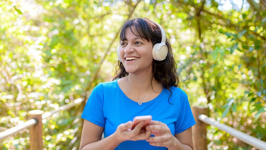 Person wearing headphones listening to music while walking outdoors