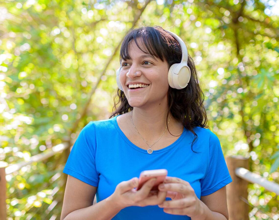 Person wearing headphones listening to music while walking outdoors