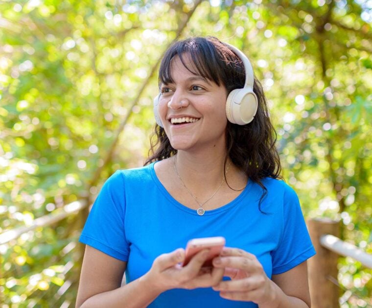 Person wearing headphones listening to music while walking outdoors