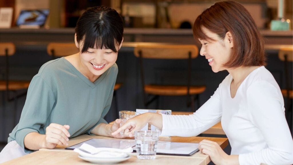 Two friends reading cafe menu