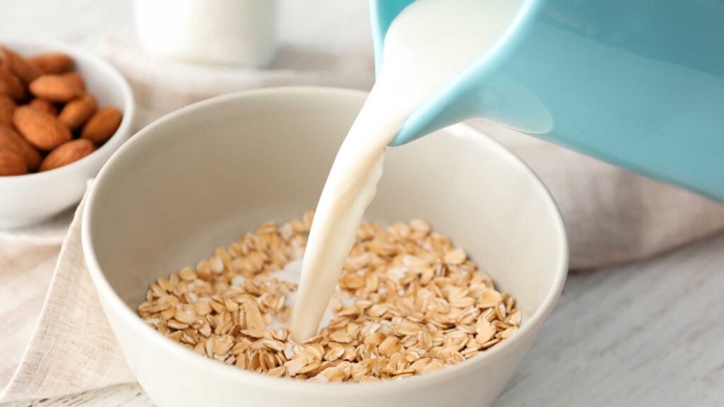 Pouring milk onto a bowl of oats