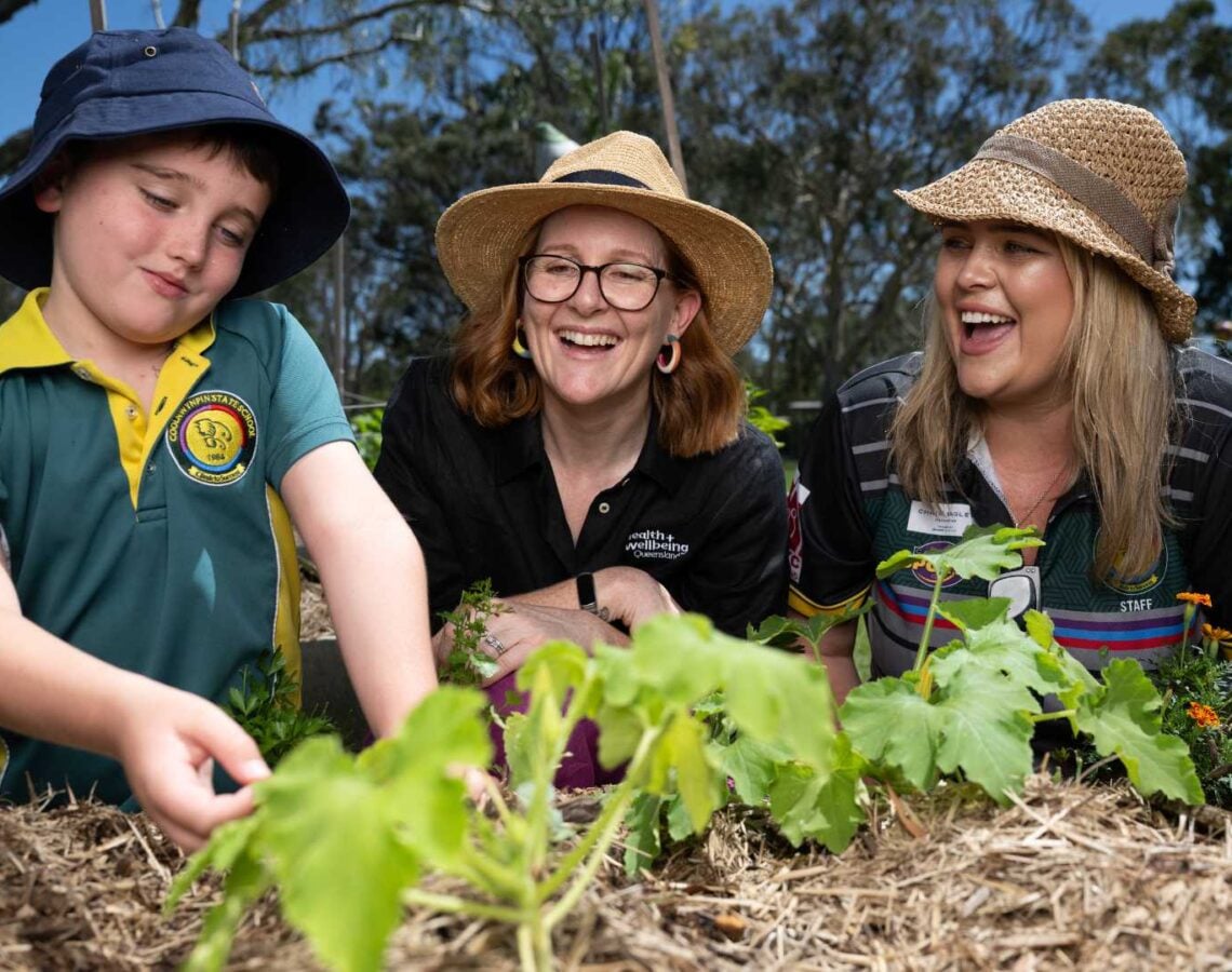 Pick of the crop program with student, teacher and staff working in the garden