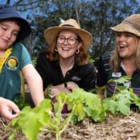 Pick of the crop program with student, teacher and staff working in the garden