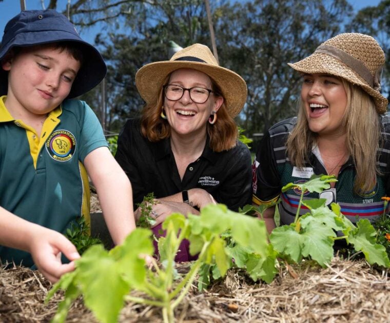 Pick of the crop program with student, teacher and staff working in the garden