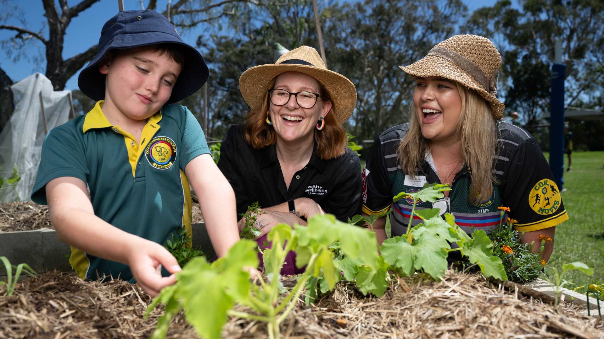 Pick of the crop program with student, teacher and staff working in the garden