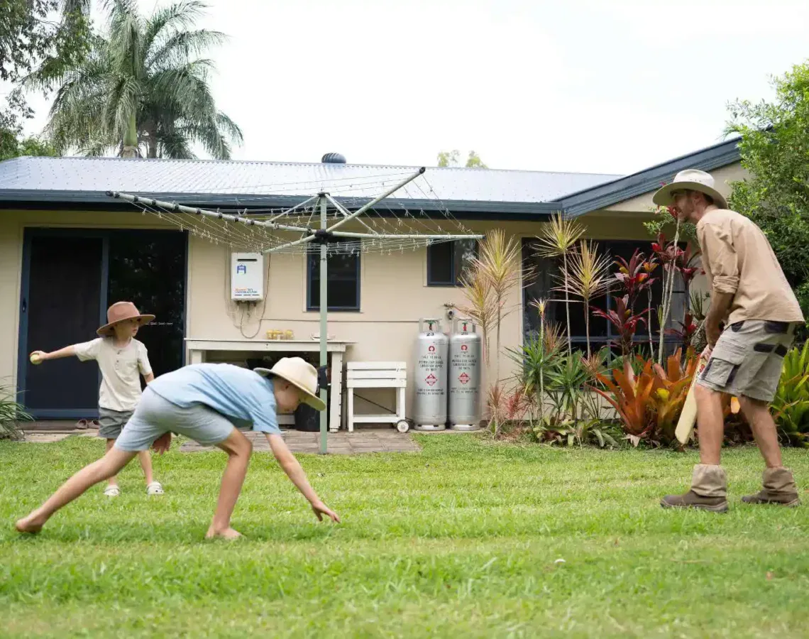 Family playing backyard cricket