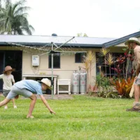Family playing backyard cricket