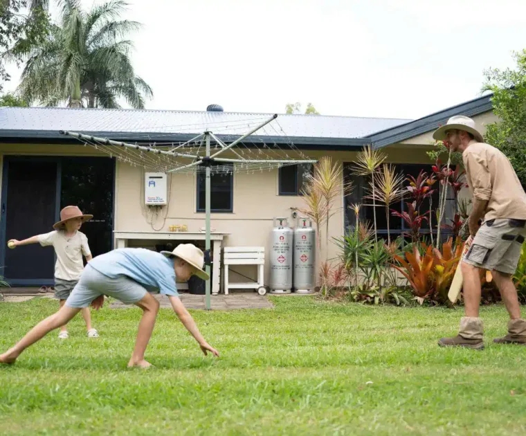 Family playing backyard cricket