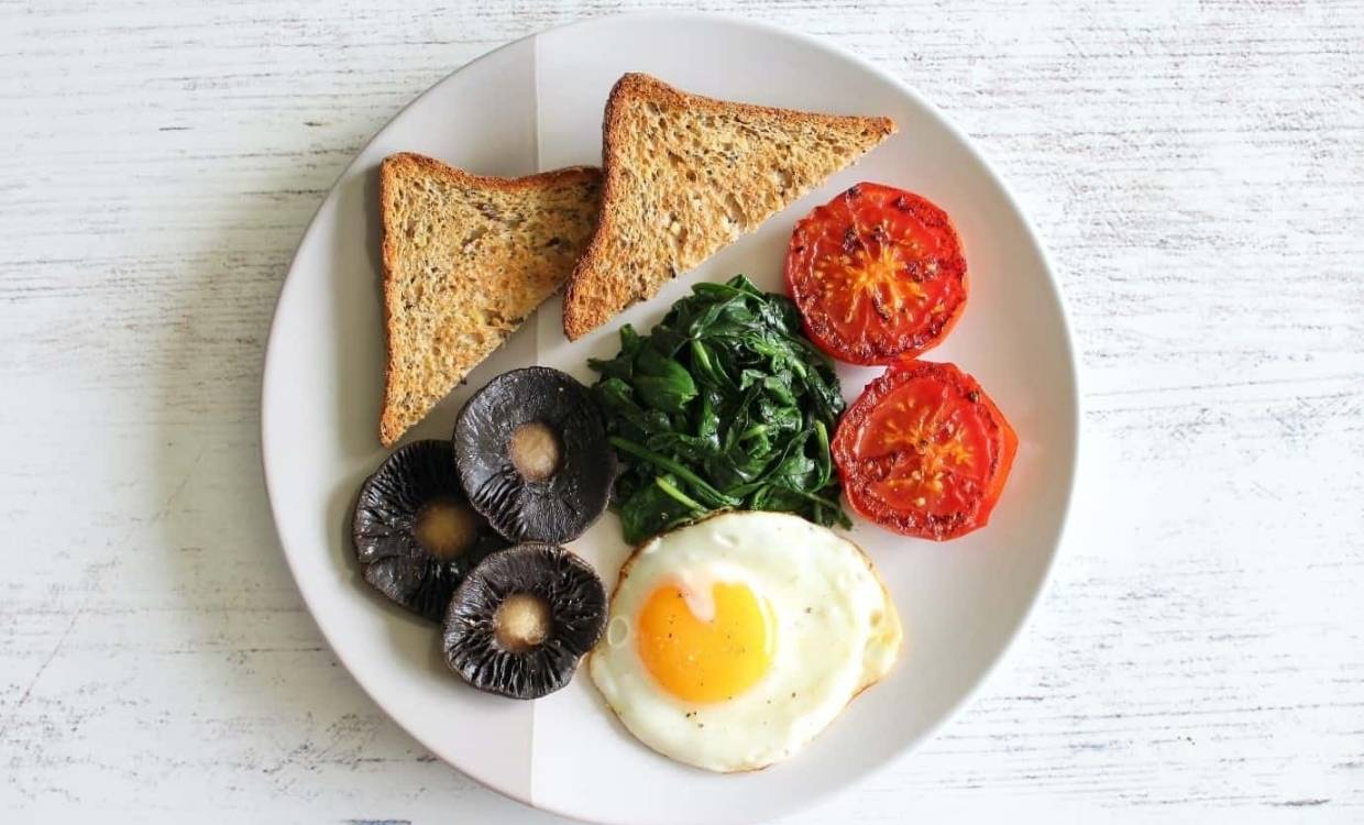 Breakfast featuring egg, mushroom, spinach and tomato with wholegrain toast
