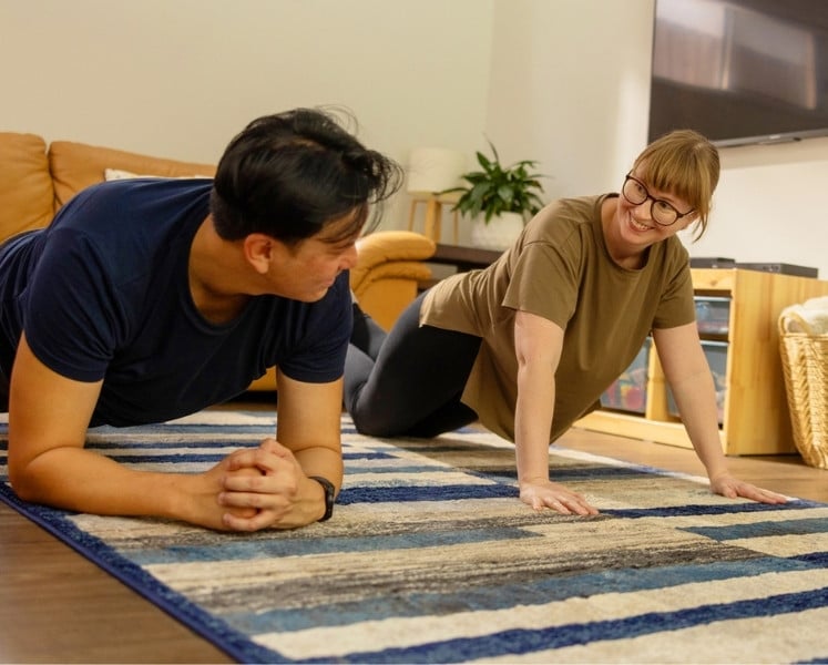 Couple workout doing plank pushup in lounge room