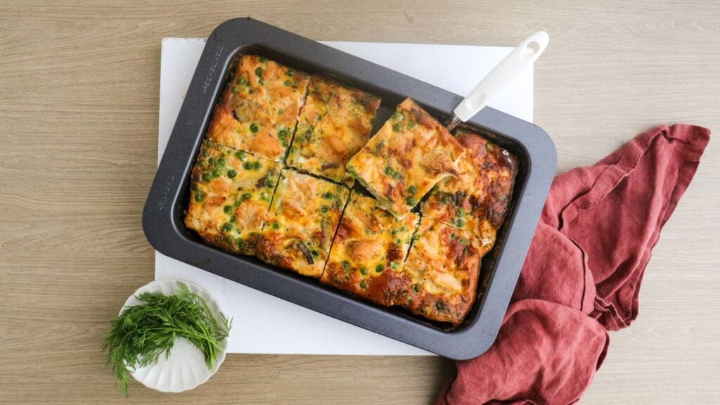 Salmon and leek frittata in baking pan sliced into 8 pieces