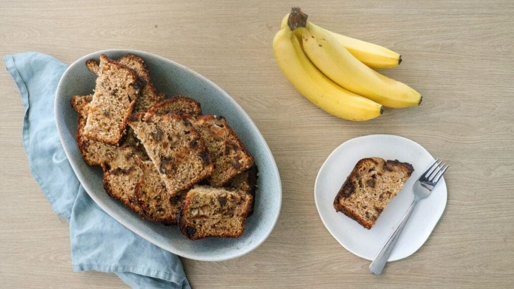 Slices of banana bread in a bowl, with one slice on a plate