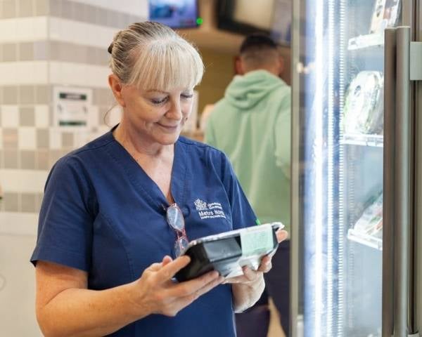 A Better Choice Healthcare - Nurse choosing healthy lunch option from canteen fridge