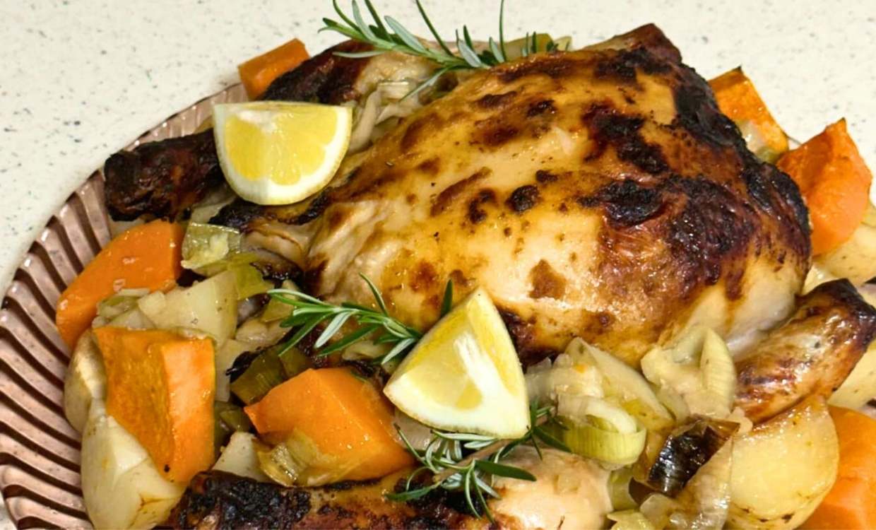 Roasted piece of chicken surrounded by roasted vegetables