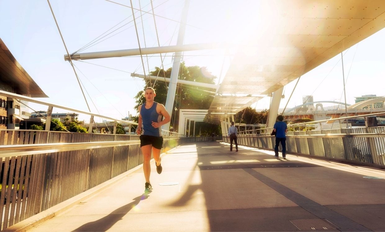 Young man in active wear running across the Kurilpa Bridge, Brisbane
