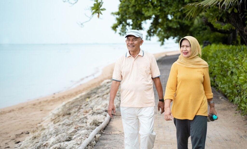 Multicultural couple walking along beachside pathway
