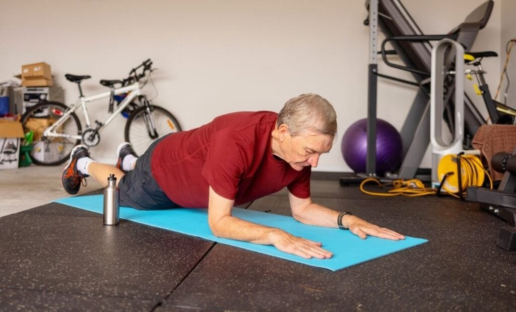 Older man does an at-home workout in the garage
