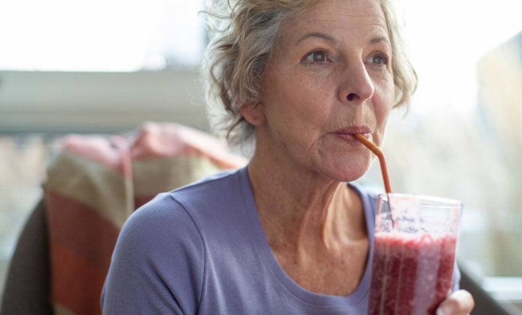 Older woman sips on a healthy smoothie